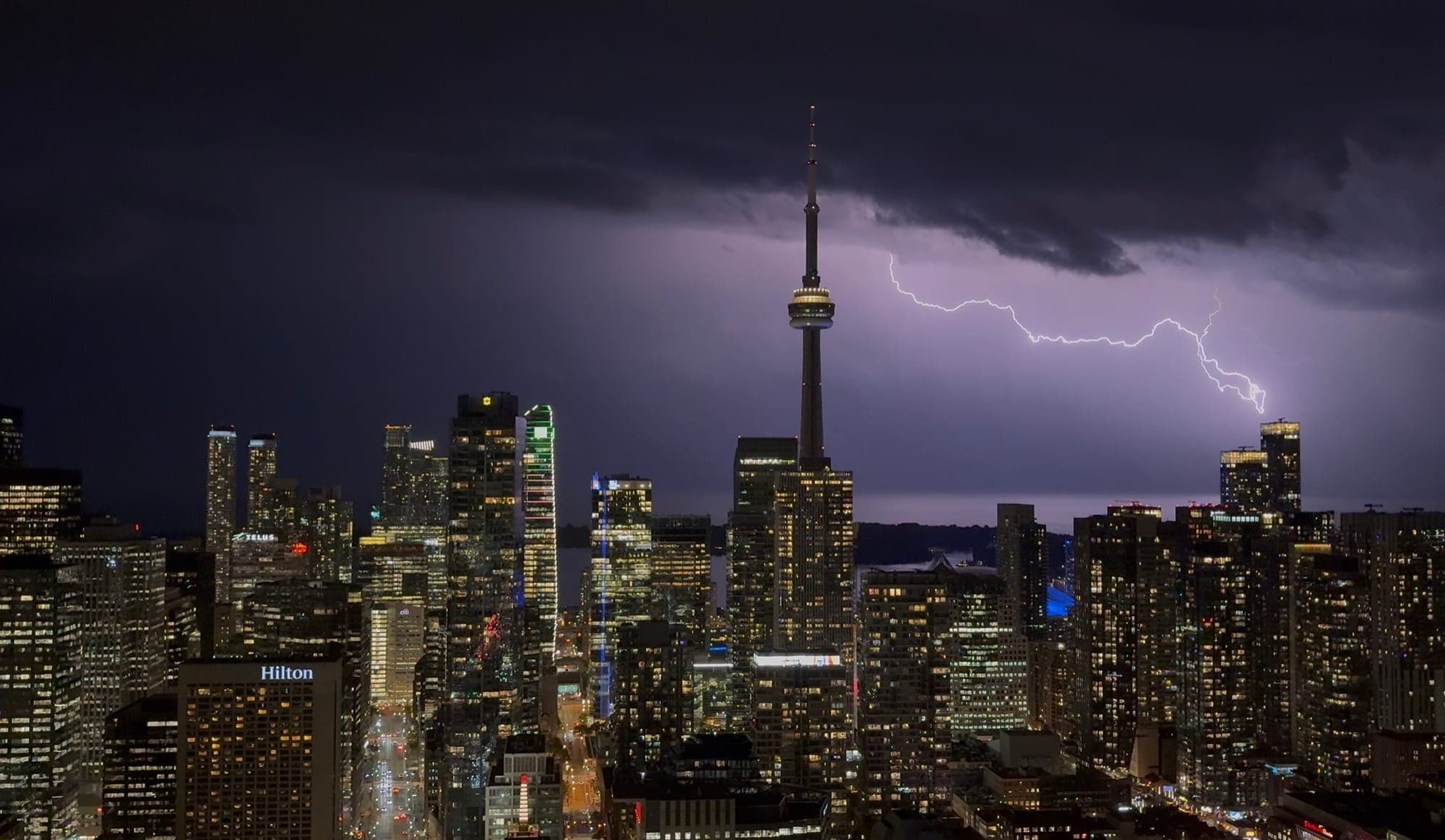 Toronto skyline at night, lightning striking behind the CN Tower